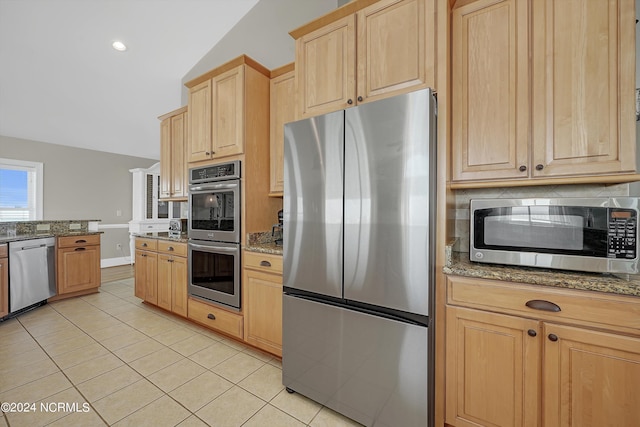 kitchen featuring tasteful backsplash, appliances with stainless steel finishes, light stone counters, light brown cabinetry, and light tile patterned flooring