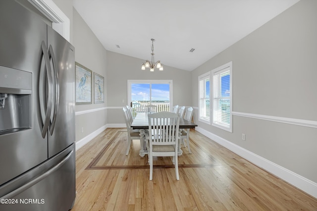 dining room featuring a chandelier, vaulted ceiling, light wood-style flooring, and baseboards