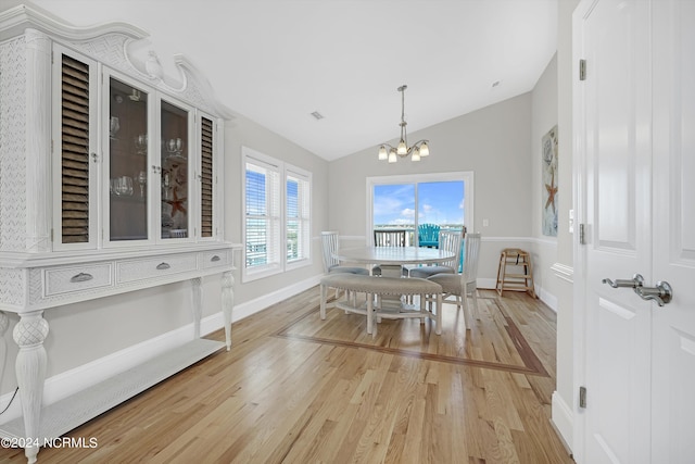 dining room with a chandelier, lofted ceiling, visible vents, baseboards, and light wood-type flooring