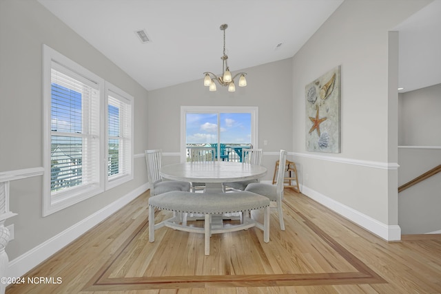 dining area with lofted ceiling, light wood finished floors, baseboards, and visible vents