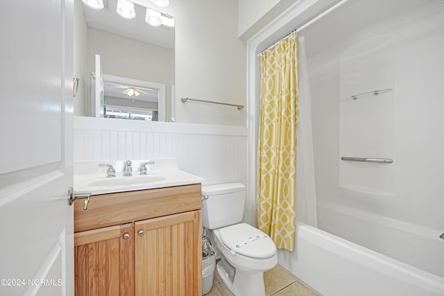 full bath with wainscoting, toilet, tile patterned floors, shower / bath combination with curtain, and vanity