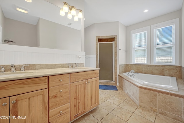 bathroom with double vanity, a stall shower, a bath, and tile patterned floors