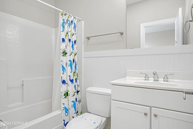 full bathroom featuring shower / bath combo, wainscoting, vanity, and toilet