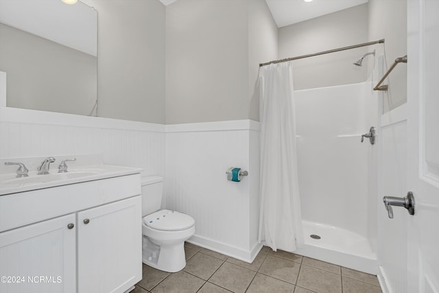 full bathroom featuring curtained shower, toilet, a wainscoted wall, vanity, and tile patterned floors