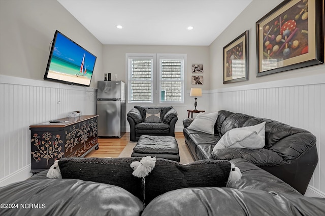 living room with recessed lighting, a wainscoted wall, and light wood-style flooring