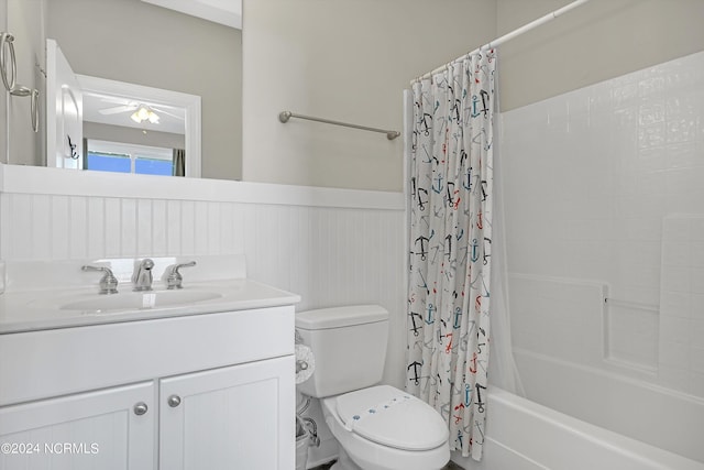 bathroom with wainscoting, vanity, toilet, and shower / bathtub combination with curtain