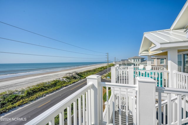 balcony featuring a water view and a beach view