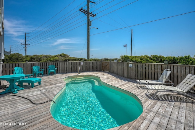 view of swimming pool featuring a fenced in pool and a wooden deck