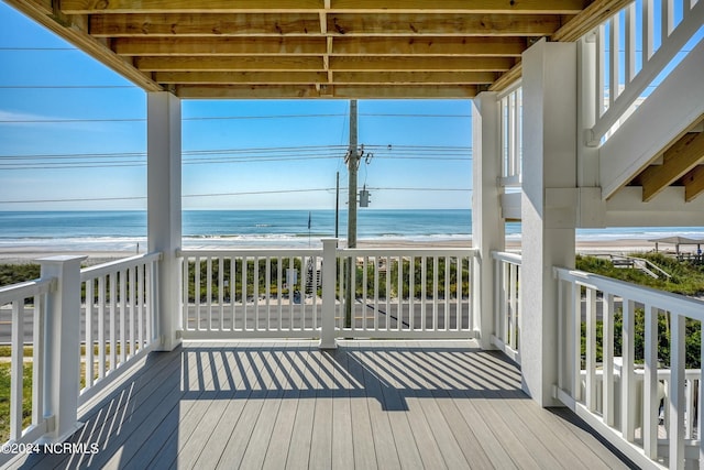 deck featuring a view of the beach and a water view