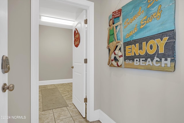 corridor with tile patterned flooring and baseboards