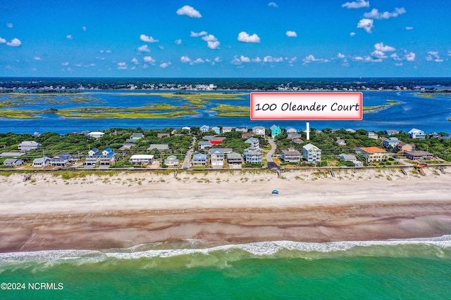 birds eye view of property featuring a water view and a beach view