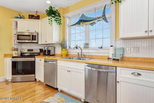 kitchen with white cabinetry, appliances with stainless steel finishes, light countertops, and a sink