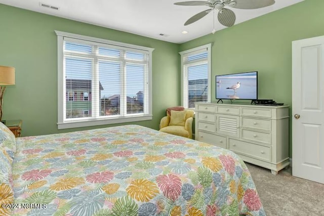 carpeted bedroom featuring ceiling fan and visible vents