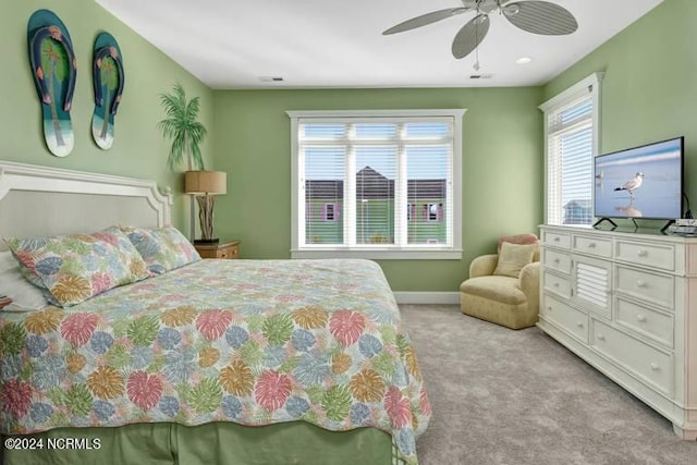 carpeted bedroom with a ceiling fan, visible vents, and baseboards