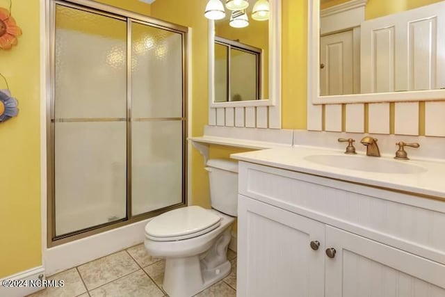 bathroom with a stall shower, tile patterned flooring, vanity, and toilet