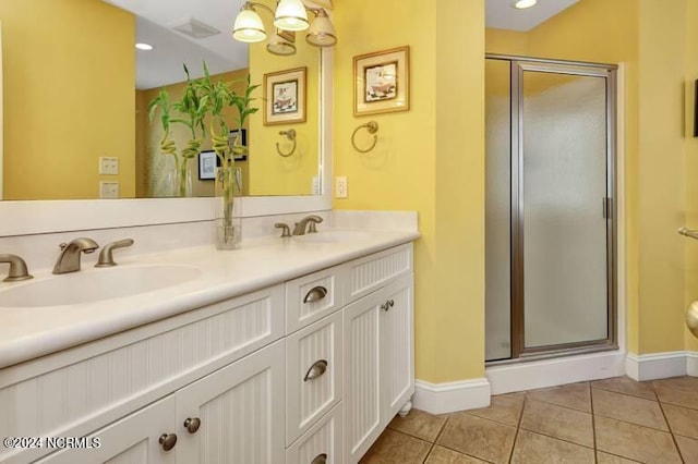 bathroom with a stall shower, tile patterned flooring, a sink, and double vanity