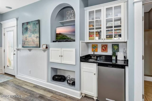 bar with wet bar, a sink, dishwashing machine, and wood finished floors