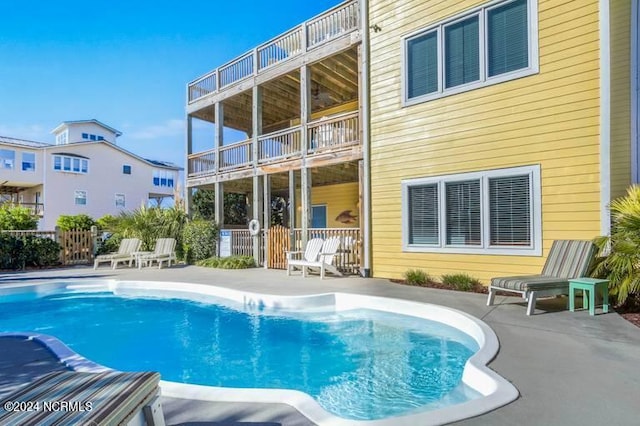 rear view of house featuring a balcony and a patio