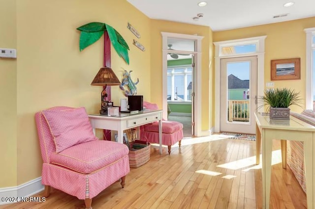 living area with hardwood / wood-style floors, recessed lighting, and baseboards