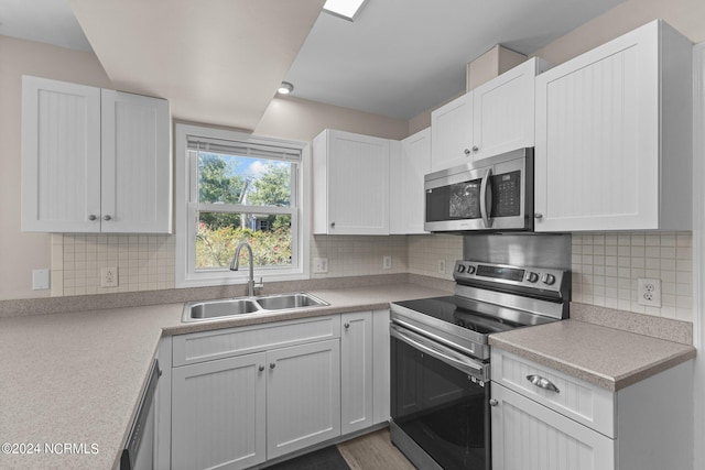 kitchen with white cabinets, appliances with stainless steel finishes, and sink