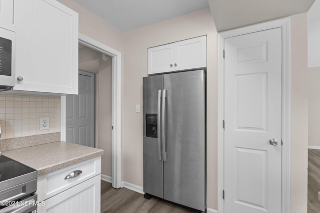 kitchen with white cabinets, stainless steel refrigerator with ice dispenser, dark hardwood / wood-style floors, tasteful backsplash, and range