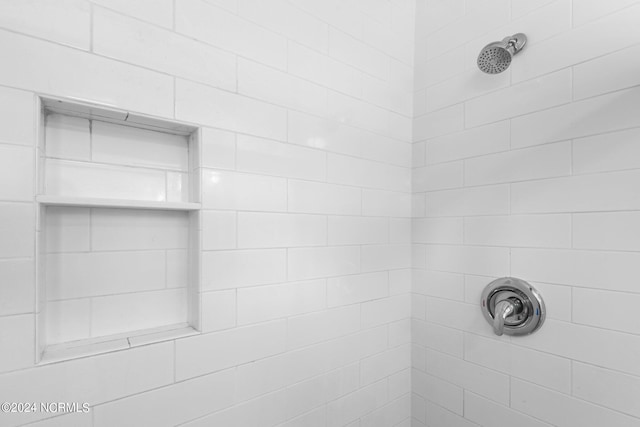 interior details with a tile shower