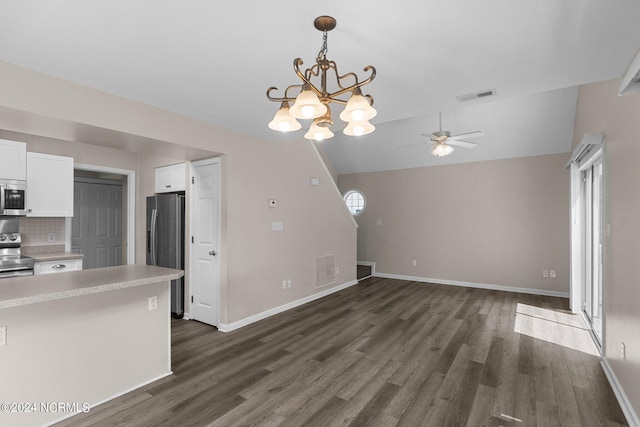 kitchen with dark wood-type flooring, tasteful backsplash, vaulted ceiling, white cabinets, and appliances with stainless steel finishes