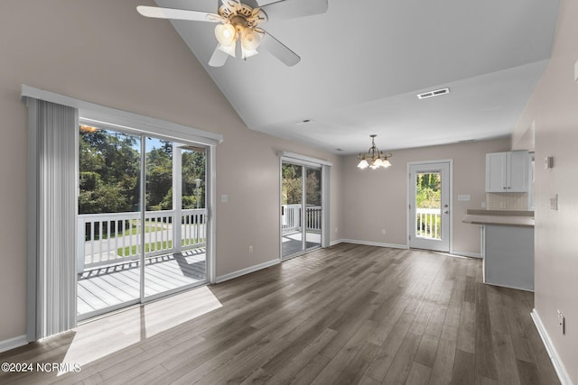 unfurnished living room featuring ceiling fan with notable chandelier, dark hardwood / wood-style flooring, and lofted ceiling