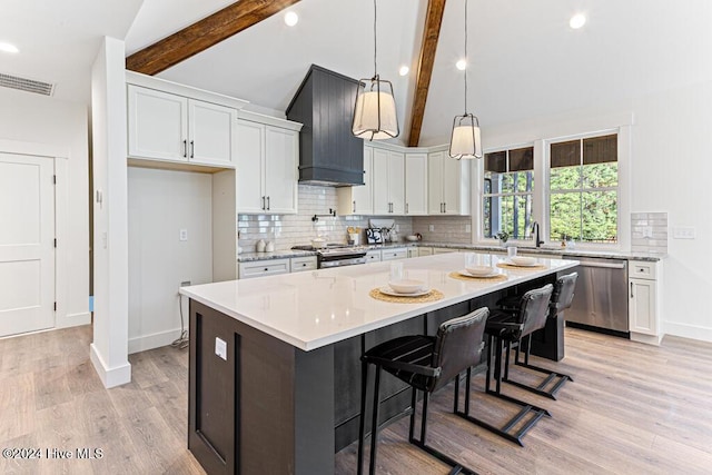 kitchen featuring vaulted ceiling with beams, white cabinetry, stainless steel appliances, and tasteful backsplash