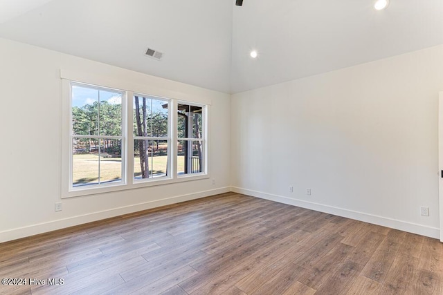 unfurnished room featuring vaulted ceiling and light hardwood / wood-style flooring