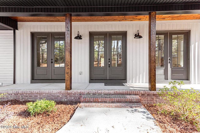 view of exterior entry featuring a porch and french doors