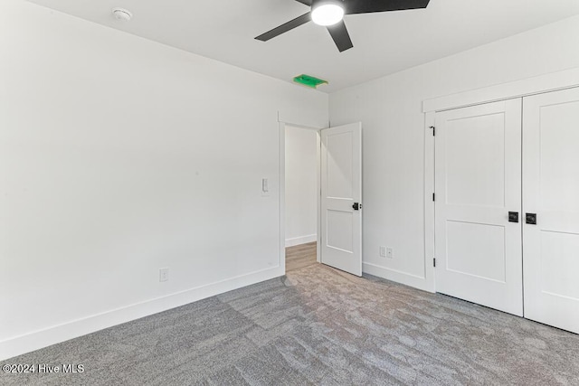 unfurnished bedroom featuring light carpet, a closet, and ceiling fan