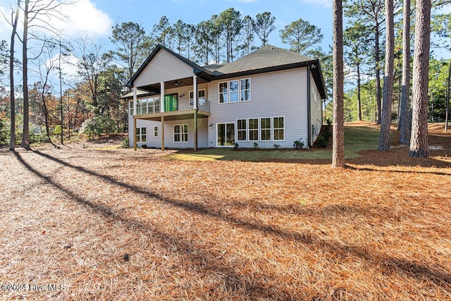 rear view of house with a lawn, ceiling fan, and a balcony