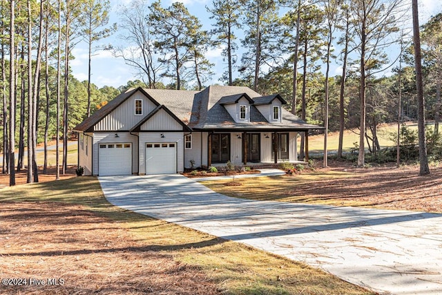 modern inspired farmhouse featuring covered porch and a garage