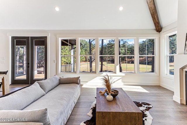 living room featuring plenty of natural light, lofted ceiling with beams, and hardwood / wood-style flooring