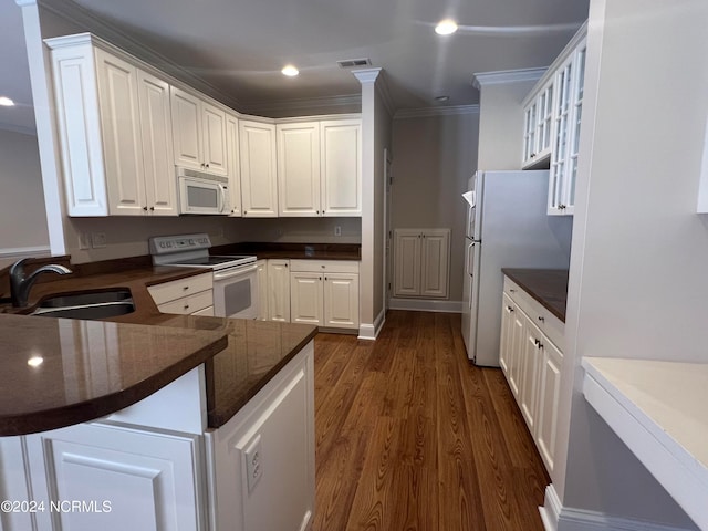 kitchen featuring white cabinets, dark hardwood / wood-style floors, kitchen peninsula, and white appliances