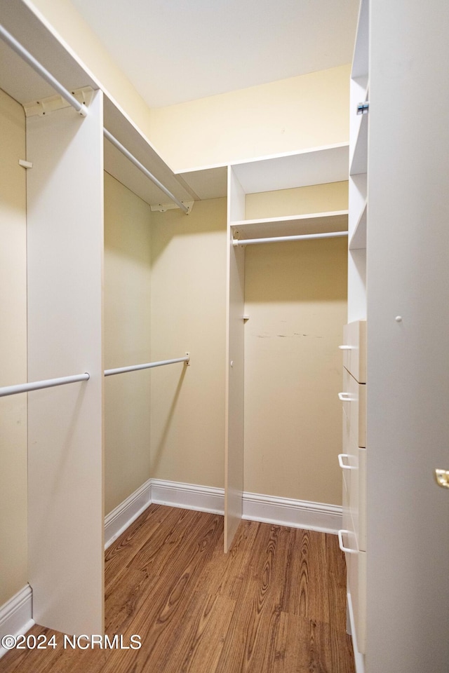 walk in closet with hardwood / wood-style floors