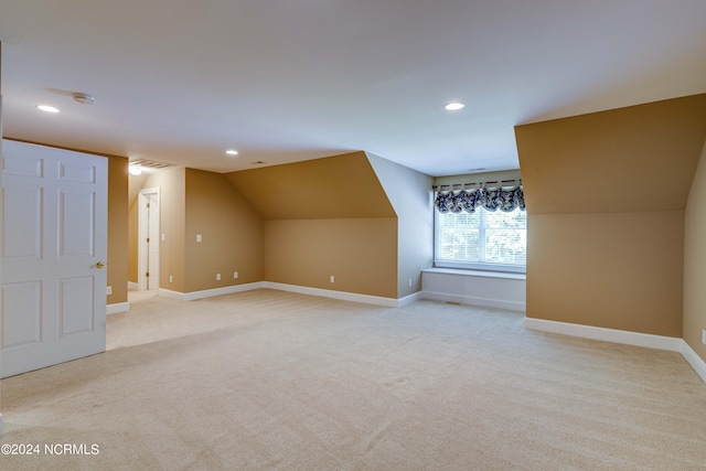 additional living space with light carpet and vaulted ceiling