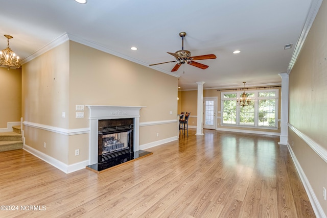 unfurnished living room with ornate columns, ceiling fan with notable chandelier, light wood-type flooring, and ornamental molding