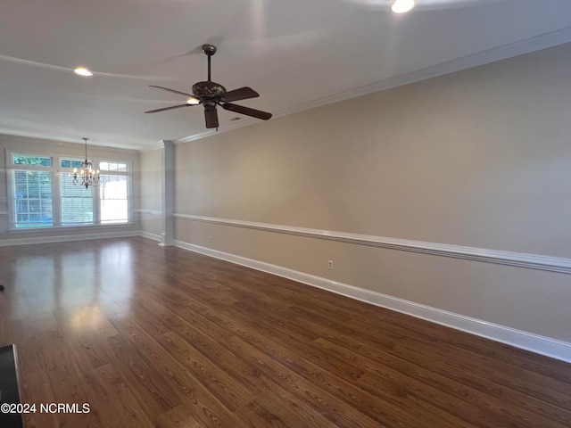 empty room with ceiling fan with notable chandelier, dark hardwood / wood-style floors, and ornamental molding