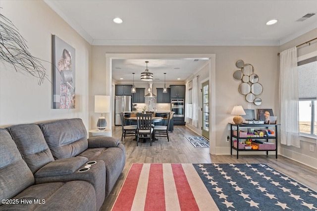 living room with crown molding and hardwood / wood-style floors