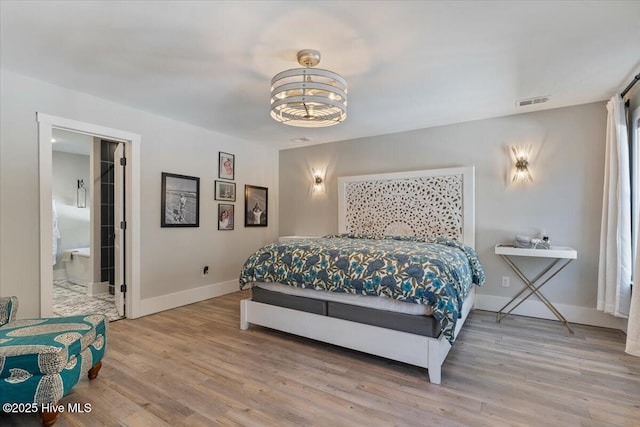 bedroom with hardwood / wood-style flooring and a chandelier