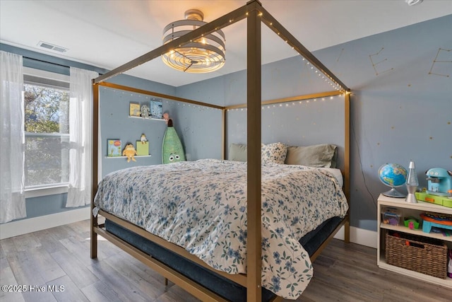 bedroom featuring hardwood / wood-style flooring and an inviting chandelier