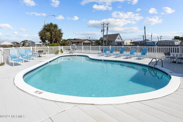 view of swimming pool with fence and a patio