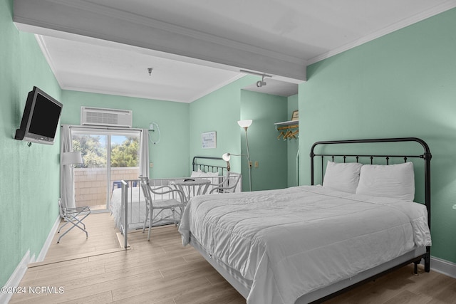 bedroom featuring baseboards, an AC wall unit, wood finished floors, and crown molding