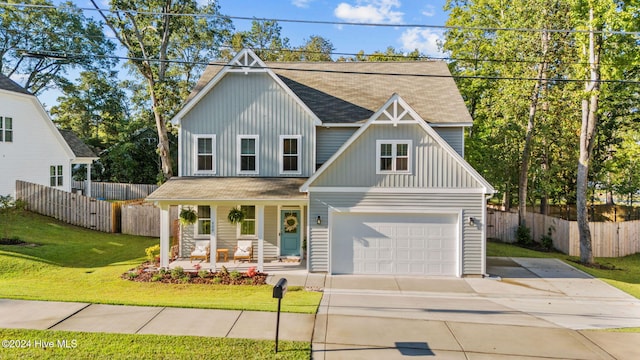 view of front of property featuring covered porch, a garage, and a front lawn