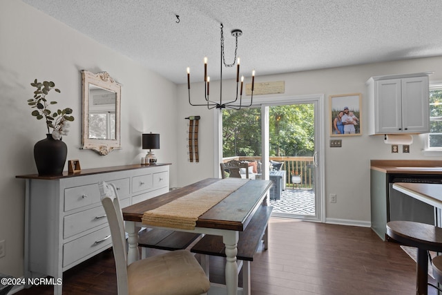 dining area featuring dark hardwood / wood-style floors, a textured ceiling, and a chandelier