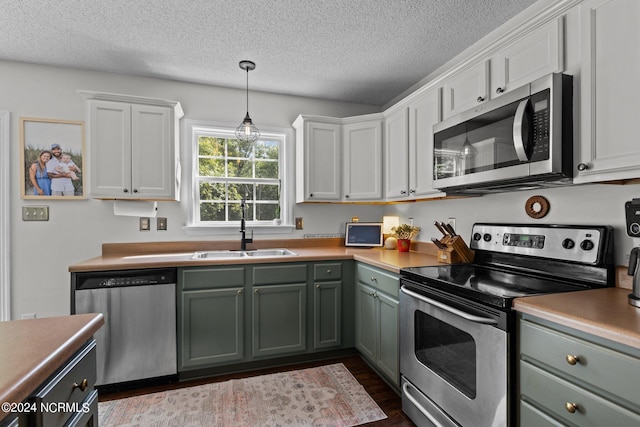 kitchen with white cabinetry, sink, dark hardwood / wood-style flooring, a textured ceiling, and appliances with stainless steel finishes