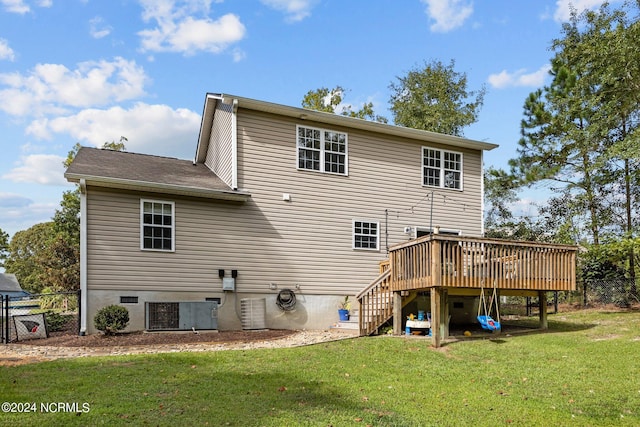 back of property with a wooden deck, a yard, and cooling unit