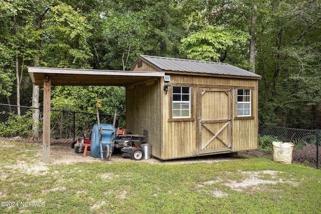 view of outbuilding featuring a lawn and a carport